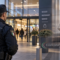 Guardia giurata davanti a un centro commerciale con simbolo della giustizia